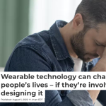 Cropped screenshot of the article as it appears on The Conversation website. Text overlays a picture of a man with lightly greying hair and tidy beard who wears a denim shirt and leans his forehead on his clasped hands.