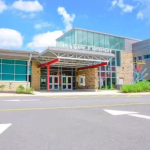 The modern, glass and brick exterior entrance of William F. Cooke Jr. Elementary school
