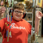 Emmett Tolis stops to look at wind chimes for sale at the Mercantile. He wears isolation headphones.
