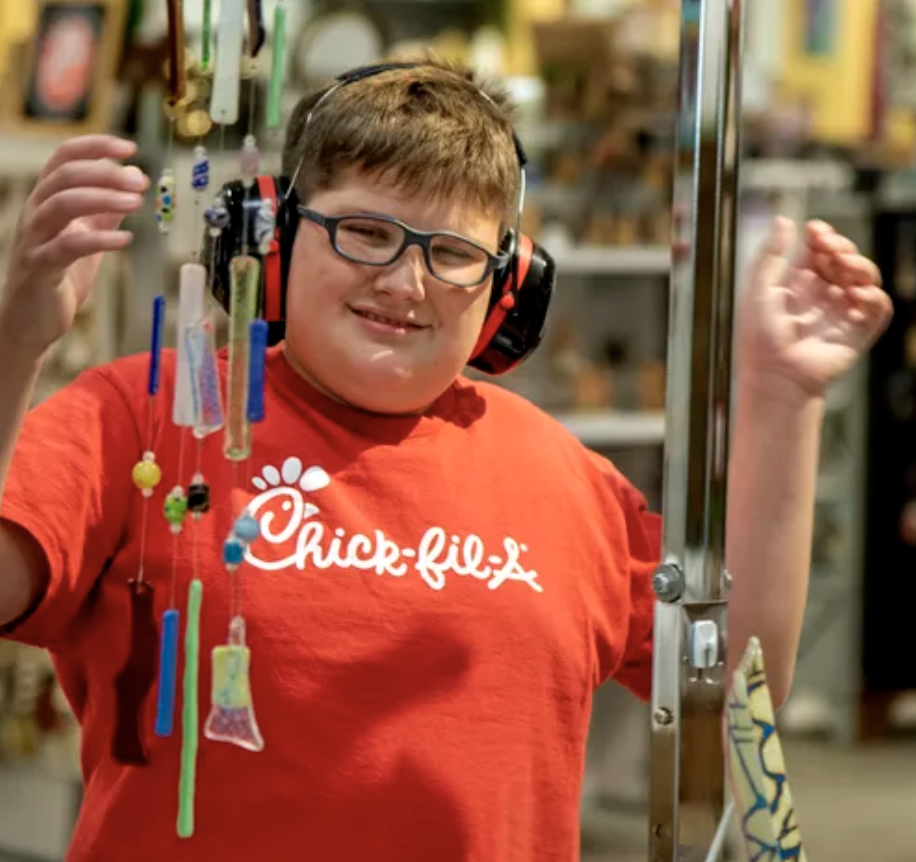 Emmett Tolis stops to look at wind chimes for sale at the Mercantile. He wears isolation headphones.