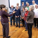 Gallaudet University president Roberta J. Cordano speaks with deaf printers who once worked at The Washington Post.