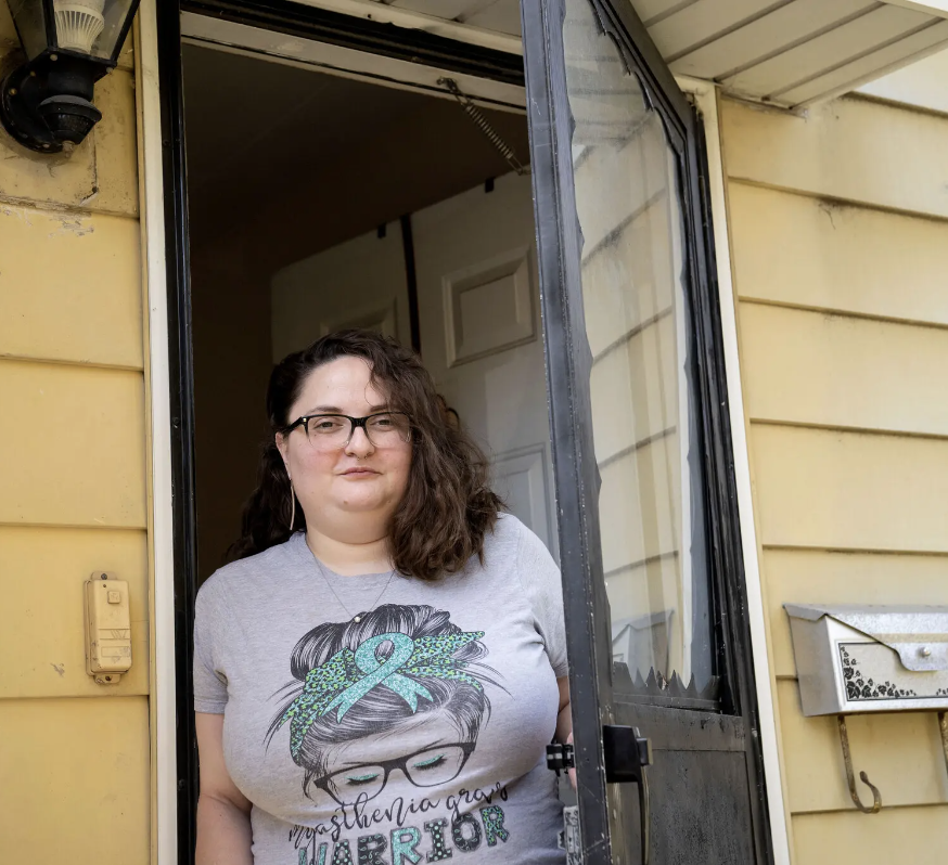 Kathryn Wiltz leans out of an outside door at her home.