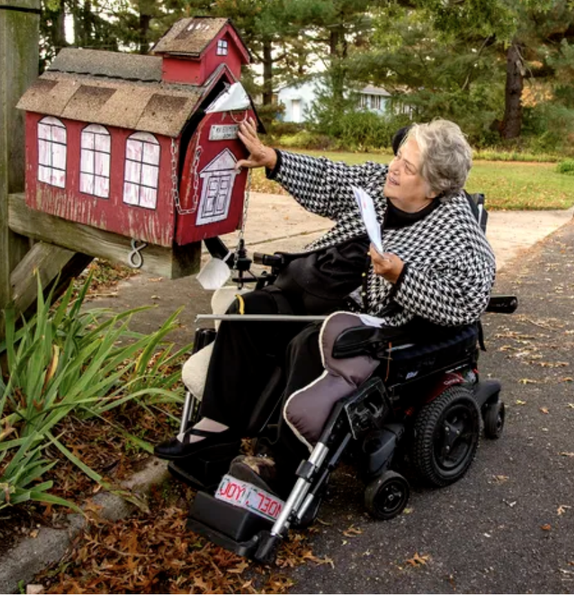 Katherine Vaczi, a retired teacher, picks up her mail — from the schoolhouse mailbox — at her home in Gloucester County.
