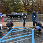 Students from UD's Access:Ability Scholars program measure a hashed area for accessible parking.