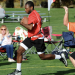 A Special Olympics athlete runs down the football field.