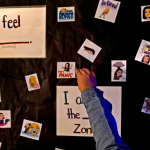 A child's hand reaches for a square of paper with a "Don't Panic" bitmoji