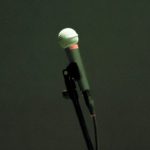A wired microphone on a stand.
