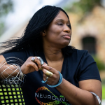 Morénike Giwa Onaiwu is an adult woman wearing a variety of jewelry that may also serve as fidget devices. She wears a neurodivergent t-shirt