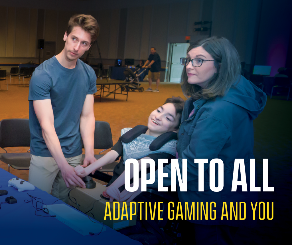 Drew Redepenning helps a child in a wheelchair and their mother with adaptive gaming equipment.