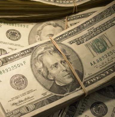 Gathered stacks of US paper currency.