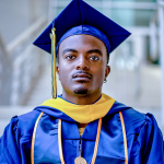 A person with dark toned skin wearing blue and gold academic regalia