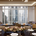 A very well appointed apartment with large windows overlooking a city.