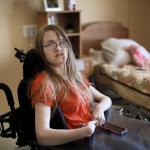 A person in a power chair in a bedroom
