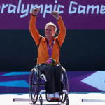 Esther Vergeer in her competition wheelchair raises her arms in victory at the Paralympic Games.