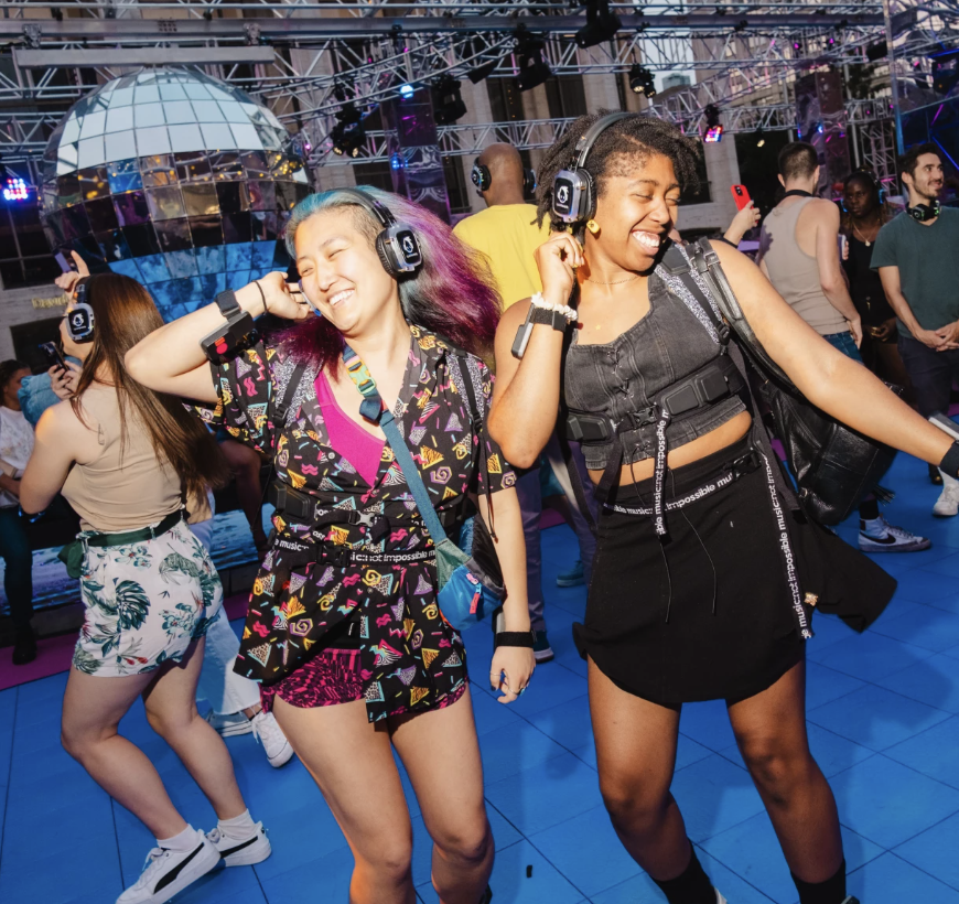 Two young adults wear haptic devices and dancing