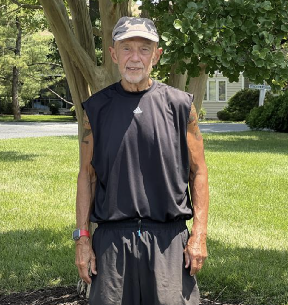 Jerry Lechliter standing in athletic clothing in front of a tree